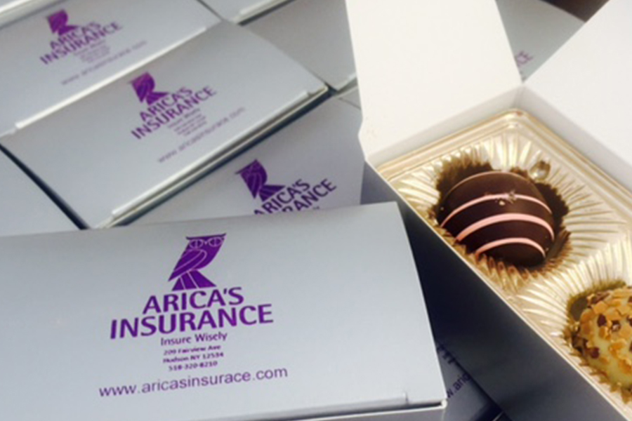Blog - Display of Single Serve Boxes of Chocolate Covered Strawberries With Arica's Insurance Logo on Them
